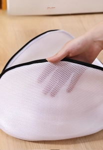 Close-up of the breathable sandwich mesh fabric and sturdy black zipper on a shoe laundry bag