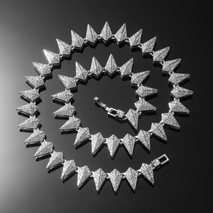 Detailed close-up of a silver-toned hip hop spiked necklace with sparkling rhinestones