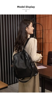 Detailed view of black litchi pattern leather backpack with multiple zipper compartments