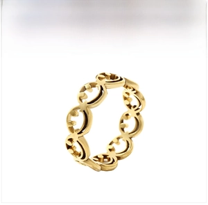 Close-up of golden stainless steel ring featuring laser-cut hollow smiley face patterns