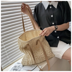 Detailed macro view of cream crochet woven bag with brown leather shoulder straps