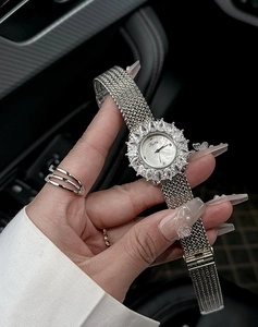Dettaglio ravvicinato di un orologio di lusso argento con ghiera di diamanti e quadrante madreperla