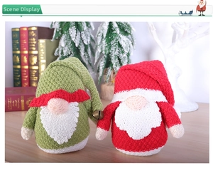 Detail of handcrafted knitted Christmas gnomes with metal bells and festive scenery