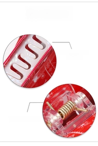 Detail of red Christmas hair claw clip featuring snowflake pattern and strong metal spring