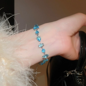 Detail of blue cubic zirconia bracelet with mixed geometric cuts on female wrist