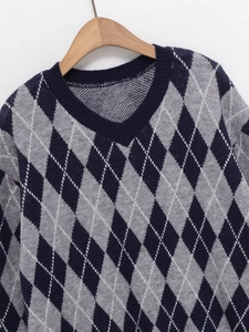 Detail of argyle knit pattern and ribbed V-neckline on dark blue women sweater
