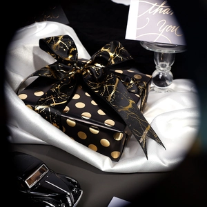 Premium black gift box with gold foil polka dots and elegant satin ribbon decoration