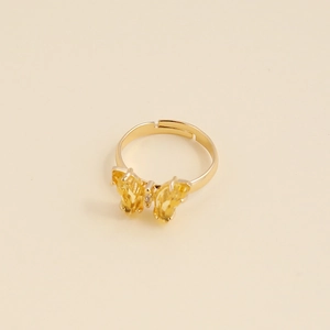 Gros plan d'une bague papillon dorée avec zircon jaune et anneau ouvert réglable