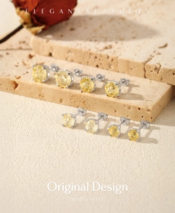 Detailed view of yellow gemstone silver studs on textured stone with elegant dried rose