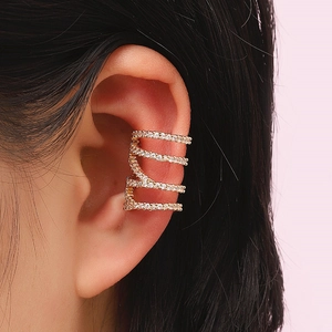 Macro shot of 4-layer spiral gold-tone ear cuff with rhinestones on model's ear