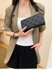 Detail of black woven leather wallet with heart embroidery and matching wrist strap