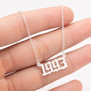 Macro detail of gothic style 1993 birth year pendant on a stainless steel chain