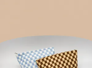 Detail of knitted checkerboard pouches showing the soft texture and durable metal zipper
