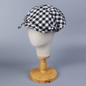 Detail of classic black and white plaid newsboy cap with premium linen texture