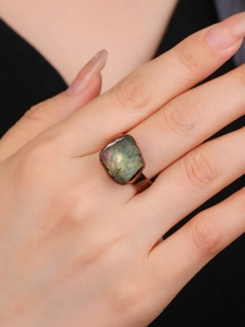 Macro di un anello regolabile in bronzo con una grande pietra grezza di fluorite verde
