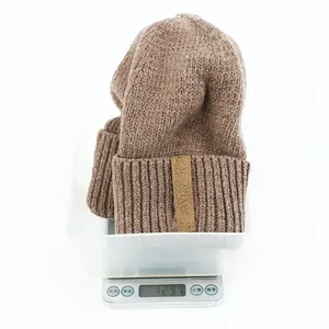 Detail shot of heavy knit beanie weight measurement at 129.4g on digital scale