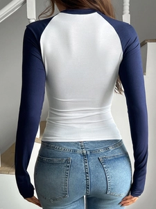 Vista posteriore di una maglietta Y2K a maniche lunghe con corpo bianco e maniche blu a contrasto