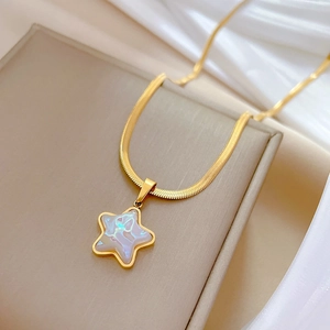 Macro detail of gold-plated starfish pendant with mother-of-pearl inlay on snake chain