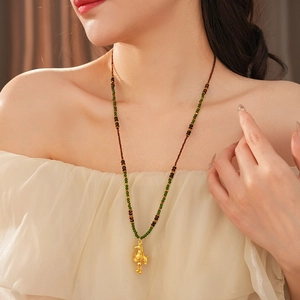 Macro detail of vintage tiger eye horse pendant with colorful beaded necklace on model