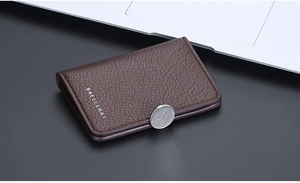 Close-up of brown lychee texture leather wallet with silver coin detail and logo