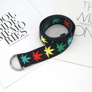 Detail of ethnic canvas belt with maple leaf print and double D-ring metal buckle
