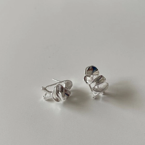 Detail view of irregular wavy 925 silver stud earrings with high-polish metallic texture