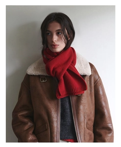 Close-up of red Australian wool scarf with rib-knit texture and brown leather jacket