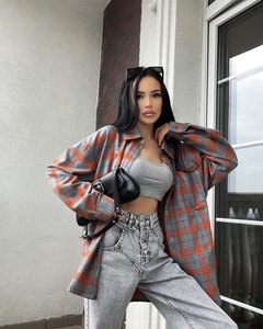 Detail of loose oversized plaid shirt with classic collar in orange and grey