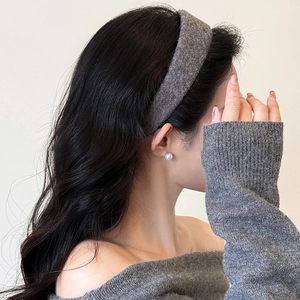 Cerchietto largo in peluche grigio scuro con orecchino di perle indossato da modella