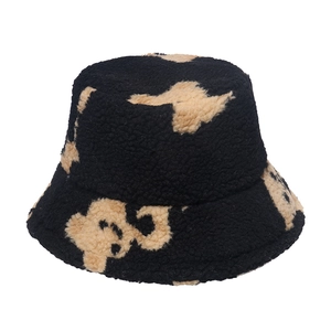 Détail du bob en peluche noire avec motif d'ours beige en laine d'agneau synthétique