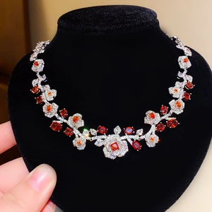 Gros plan détaillé du collier floral avec pierres rouges et cristaux sur buste velours