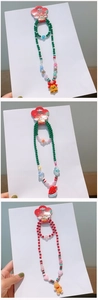 Detail of Christmas beaded jewelry sets for kids with Santa, hat, and gingerbread charms