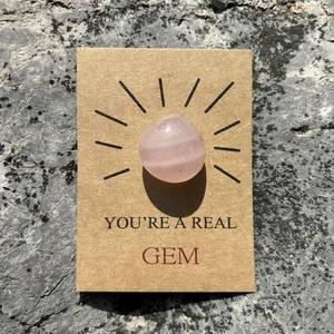Detail of rose quartz crystal stone on kraft paper gift card with YOU'RE A REAL GEM text