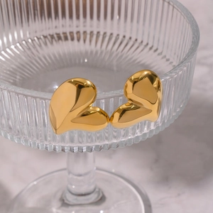 Polished gold stainless steel heart stud earrings on elegant textured glass rim