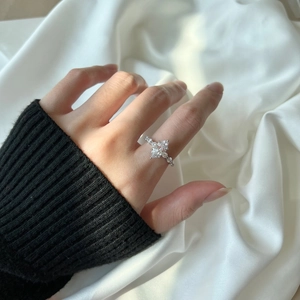 Close-up of S925 silver marquise-cut zircon ring worn on finger over silk fabric