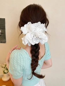 Close-up of white double-layered lace scrunchie with floral embroidery on a ponytail