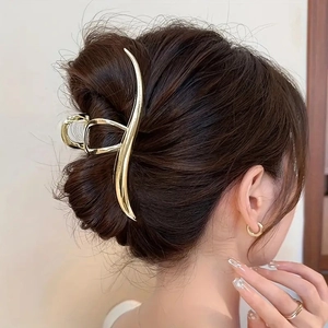Pince à cheveux élégante en métal doré en forme de vague sur la coiffure du modèle