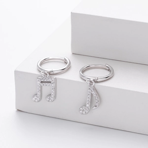 Macro view of asymmetric S925 sterling silver music note earrings with clear zircon stones