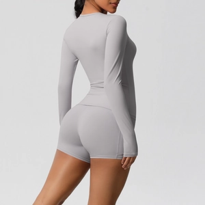 Détail d'un ensemble de yoga gris clair avec haut à manches longues et short taille haute
