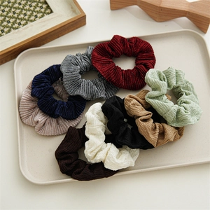 Set of 8 colorful pleated polyester hair scrunchies displayed on a minimalist beige tray