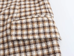 Detailaufnahme der braunen Hahnentritt-Wolltextur und der Naht an der Tasche
