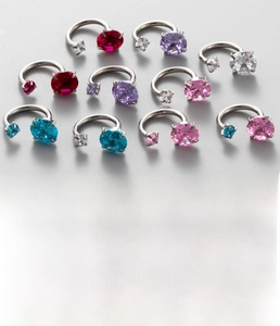 Macro shot of titanium steel horseshoe ear studs featuring sparkling zircon screw heads