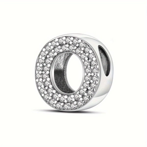 Detailed macro view of silver bead charm with sparkling pavé crystals in letter O shape