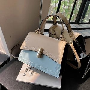 Sac bandoulière bicolore bleu et beige avec fermoir doré et coutures élégantes