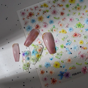 Detailed view of 5D embossed floral nail art stickers and pink cat-eye press-on nails