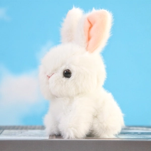 Close-up of a white plush bunny keychain with fluffy white fur and pink inner ears