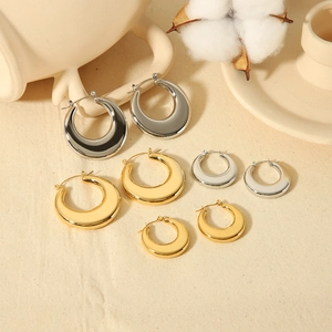 Boucles d'oreilles vintage en forme de U dorées et argentées en plusieurs tailles sur fond beige