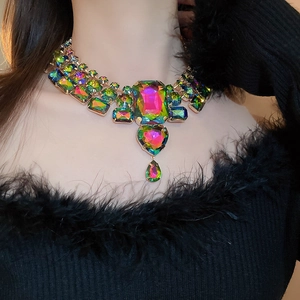 Detailed close-up of multi-shape iridescent crystal drop necklace with golden setting