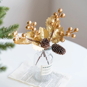 Golden Christmas berry branch with pine cones in glass vase for festive home decor