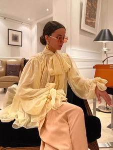 Elegant light yellow chiffon blouse with a large bow tie neck and layered ruffle cuffs